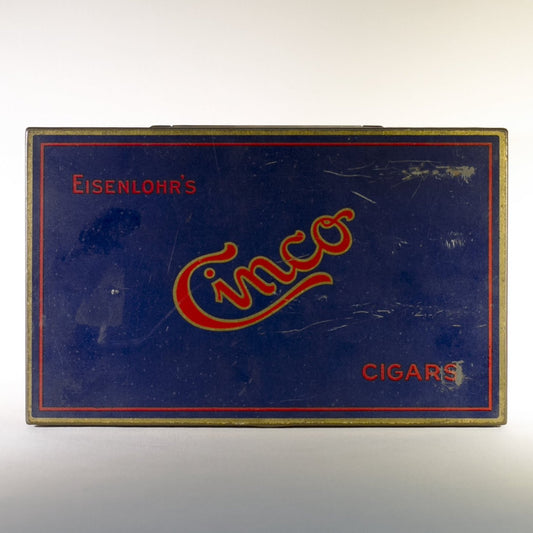 EISENLOHR'S CINCO CIGARS TIN is from the 1920s. Cinco was the chief product of the Philadelphia based cigar firm of Otto Eisenlohr and Brothers, a popular priced brand in the 1920s, producing and selling 210 million of the cigars. The brand was considered the largest individual seller of cigars in the United States.