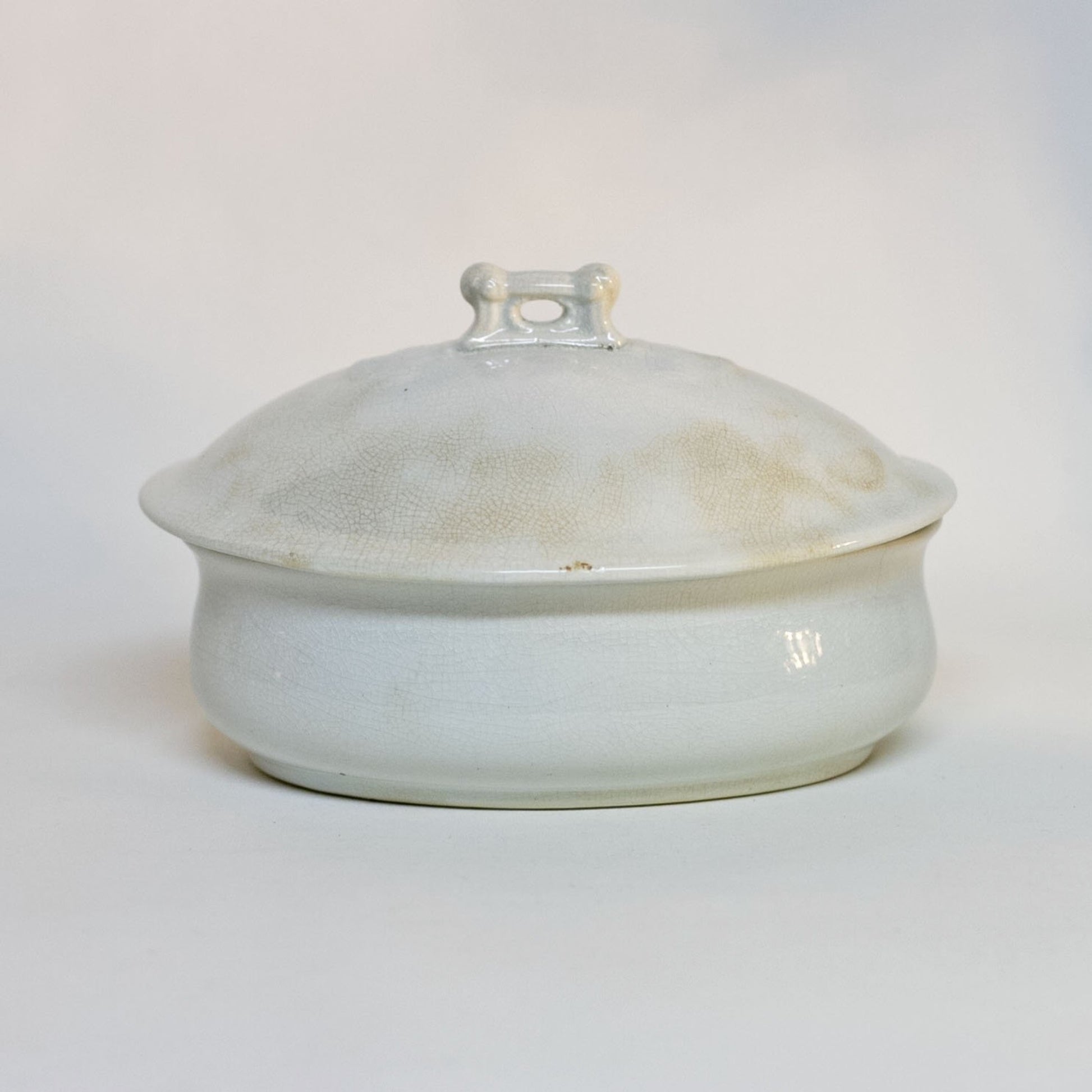 Gorgeous white antique IRONSTONE THREE-PIECE SOAP DISH made by MELLOR, TAYLOR AND COMPANY of Burslem Stoke-on-Tent in England. Set is in the shape of a small oval tureen and complete, including the drain and lid. Stamped dating the piece to between 1880-1904. Some staining, no chips.