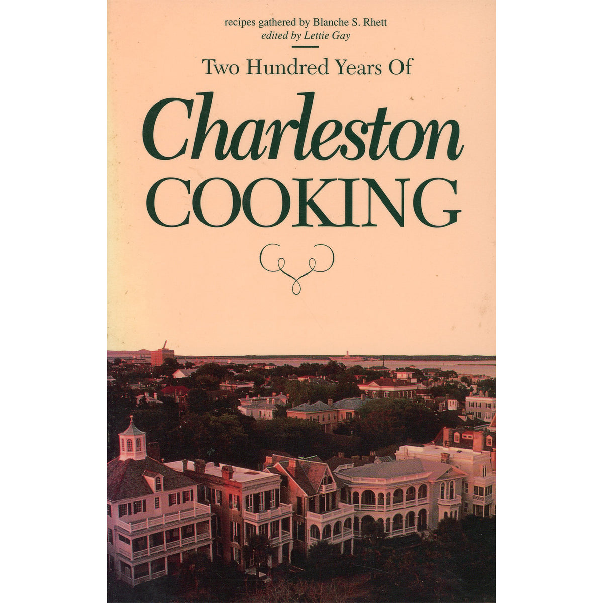 Book cover for 'Two Hundred Years Of Charleston Cooking' with large dark green title text on a warm peach background and a vintage aerial photograph of Charleston architecture along the bottom.