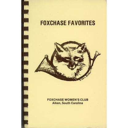 A vintage spiral-bound cookbook cover titled 'FOXCHASE FAVORITES' with a black fox illustration and the text 'FOXCHASE WOMEN'S CLUB Aiken, South Carolina' on a pale yellow background.