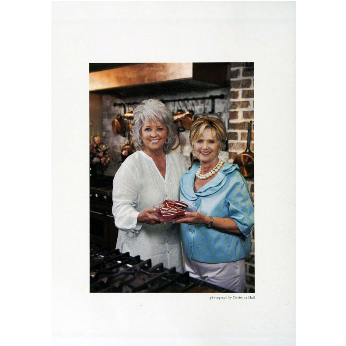 A photograph from Second Helpings by Johnnie Gabriel | Foreword by Paula Deen ©2010 Hardcover featuring author and Paula Dean standing in a kitchen.