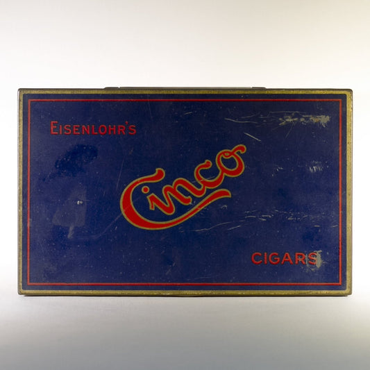 EISENLOHR'S CINCO CIGARS TIN is from the 1920s. Cinco was the chief product of the Philadelphia based cigar firm of Otto Eisenlohr and Brothers, a popular priced brand in the 1920s, producing and selling 210 million of the cigars. The brand was considered the largest individual seller of cigars in the United States. 