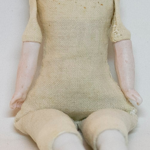 Antique CHINA SHOULDER DOLL HEAD DOLL 7 ¾” long; shoulder head measures 2" tall by 1 ⅝" wide at shoulders. Blue eyes, rosy cheeks, closed mouth and molded black curly hair with straight cut bangs. Bisque arms and legs, hand-sewn clean muslim body; stuffing appears original. No fractures. Likely German circa 1900. 