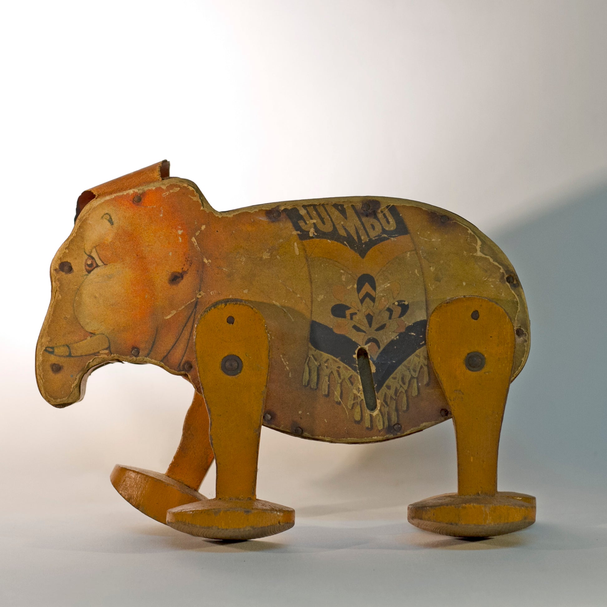 GO 'N' BACK JUMBO was one of the first Fisher Price toys. The paper lithograph decorated wooden wind-up orange elephant with circus blanket, orange oilcloth ears, and four wooden legs was offered in 1932 by Frank Tea & Spice Company of Cincinnati, Ohio as an advertising toy for its JUMBO brand peanut butter. Rare Find!