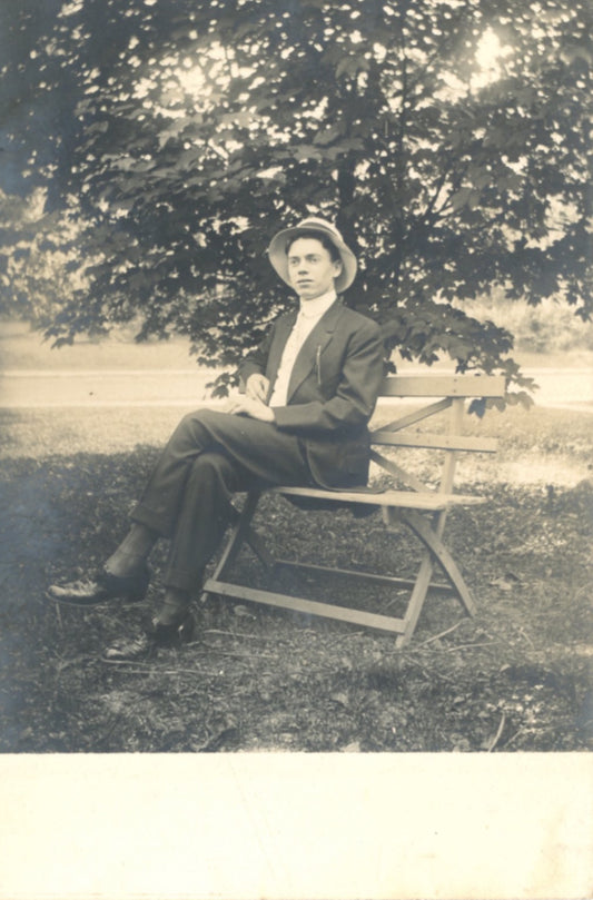 Portrait of YOUNG MAN SITTING ON PARK BENCH Antique Real Photo Postcard Circa 1910
